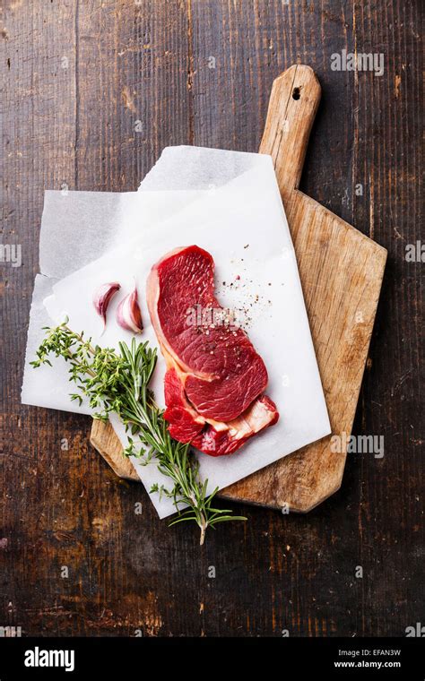 Raw Fresh Meat Ribeye Steak Entrecote And Seasonings On Cutting Board On Dark Wooden Background