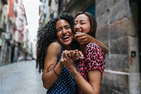 Curly Hair Woman And Ans Asian Woman Hugging And Laughing Each O By
