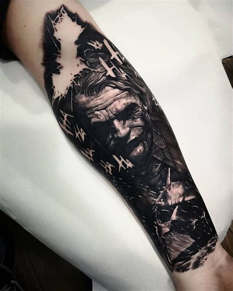 A Man S Arm Is Covered In Black And White Ink With An Image Of The Joker