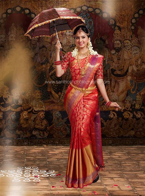 A Woman In A Red And Gold Sari Holding An Umbrella