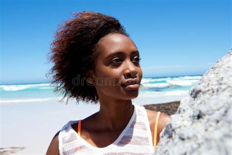 Smiling African Woman Lying On Grass Looking At Cell Phone Stock Image