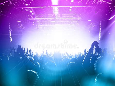 Concert Crowd Silhouettes In Front Of A Bright Stage Stock Photo