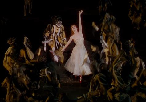 A Woman In A White Dress Dancing On Stage Surrounded By Other People
