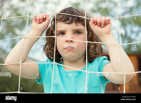Portrait Of A Girl Looking Through A Fence Stock Photo Alamy