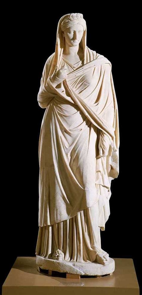 A White Marble Statue Of A Woman With Her Hands In Her Hair And Wearing