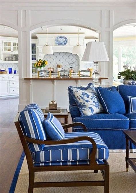 A Living Room With Blue Couches And Chairs In Front Of An Open Kitchen Area