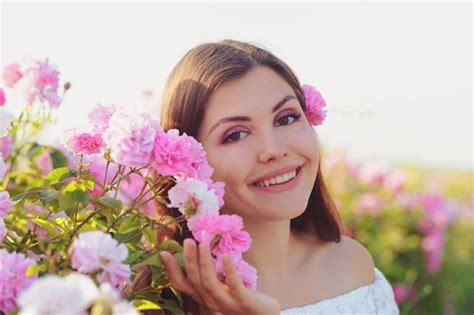 Premium Photo Beautiful Young Woman Posing Near Roses In A Garden