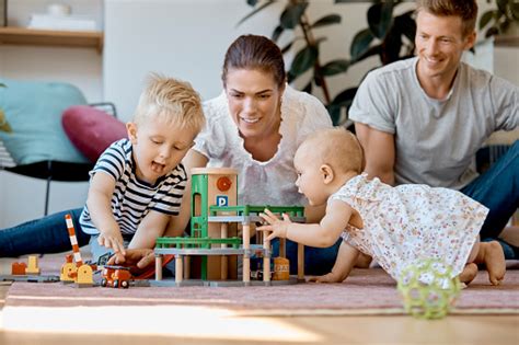 Parents Looking At Children Playing With Toys Stock Photo Download