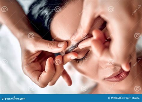 manual sculpting face massage in spa center therapist hands make facial massage on eyebrow for