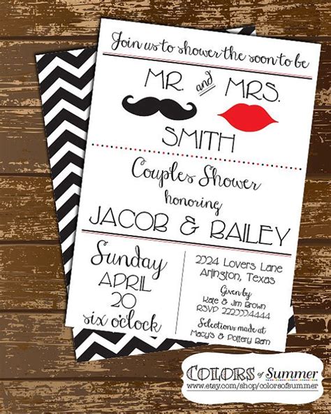 the wedding stationery is set up on top of a wooden table with black and white chevrons