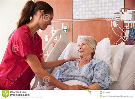 Nurse Talking To Senior Female Patient In Hospital Bed Stock Photo