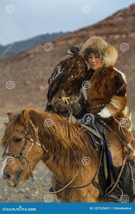 Young Kazakh Eagle Huntress Berkutchi Woman With Horse While Hunting To