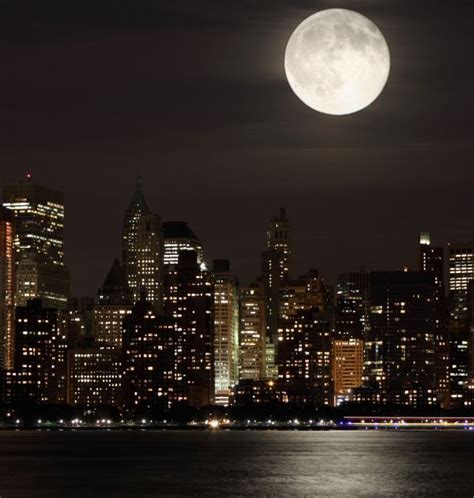 A Full Moon Is Seen Over The City Skyline In This Nighttime Photo From