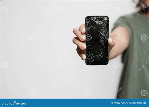 Close Up Hand Holding Broken Smartphone With Damaged Screen Stock