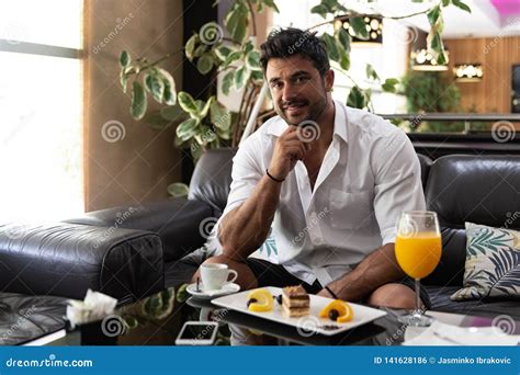 Man Relaxing On Sofa In Hotel Lobby Bar Stock Photo Image Of Rest