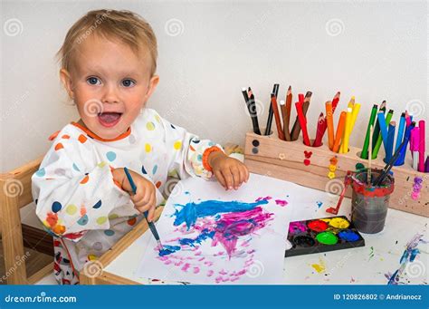 Cute Baby Is Painting With Paintbrush On Paper Stock Photo Image Of