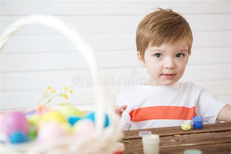 Boy Holds An Egg And Painting With Brush Preparing For Celebration Of