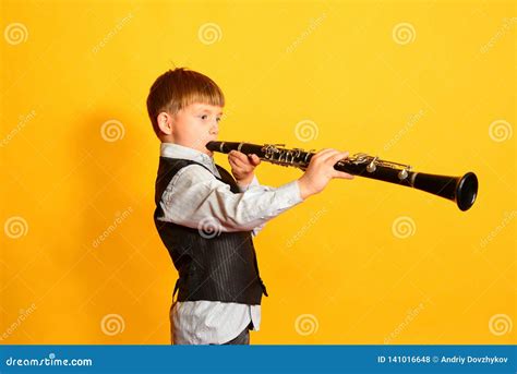 A Little Boy In A Suit Plays The Clarinet Stock Photo Image Of Plays