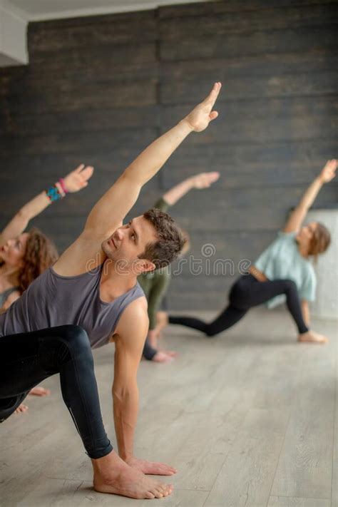 Yoga Beginners Exercising Against Grey Wall Doing Yoga Or Pilates