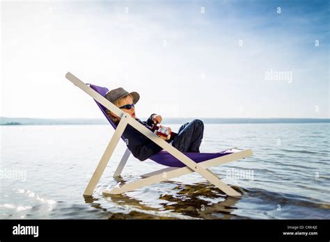Boy Relaxing In Lawn Chair In Creek Stock Photo Alamy