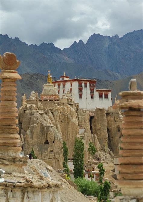 The Mountains Are Covered In Rock Formations And Buildings With Towers