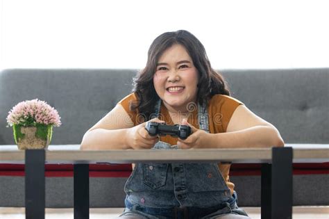 Portrait Of Happy Fat Asian Woman Sitting And Holding A Joystick