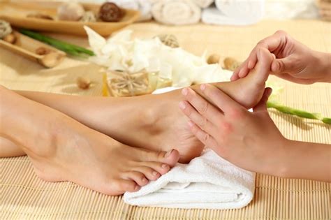 premium photo masseur making feet massage in spa salon
