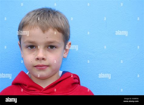 Young Boy Aged 9 Years Old In Red Top On Blue Background Short Hair
