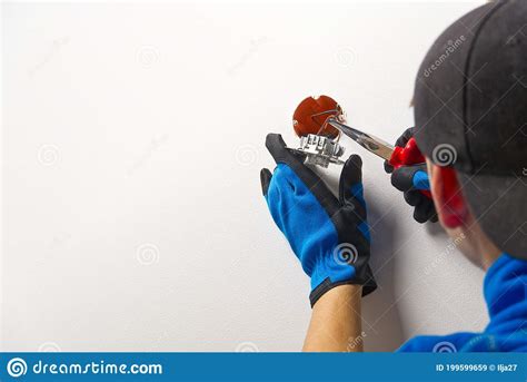 Electrician Installing Light Switch On Painted Wall With Screwdriver