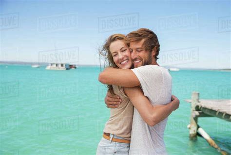 Couple Hugging Near Water Stock Photo Dissolve