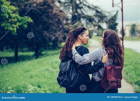 Two Beautiful Female Friends Hugging Each Other While Walking Through