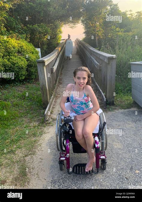 girl with ullrich congenital muscular dystrophy sits in her bathing suit in a wheelchair on a
