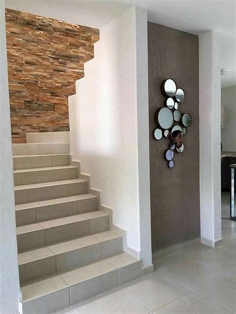 There Is A Clock That Is On The Wall Next To The Stairs In This House