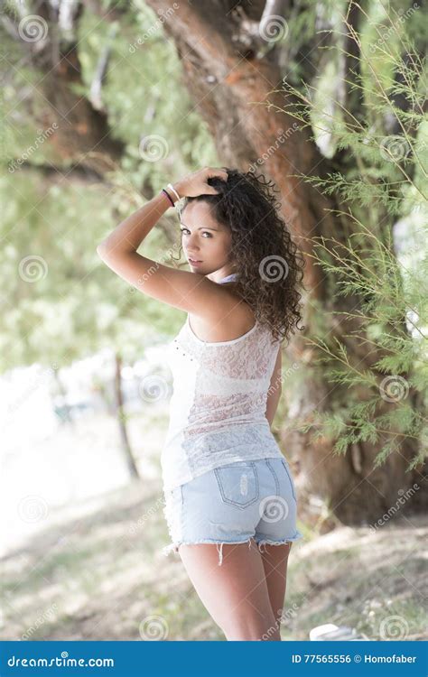 Mooi Meisje Met Krullende Haren Die Zich Onder De Bomen Bevinden Stock