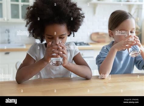 Thirsty Multiethnic Girls Children Drink Water At Home Stock Photo Alamy