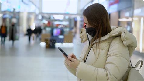 Young Woman In Shopping Mall Or Trade Center Using Smartphone Mobile