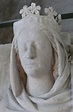 a white statue with a crown on it's head and scarf around its neck