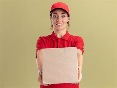 Free Photo Pleased Young Pretty Delivery Girl In Uniform Holds