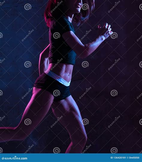 Young Sport Woman Running Jogging In Gyn In Blue And Pink Neon Light On