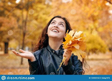 Pretty Woman Is Posing With Bunch Of Maple S Leaves In Autumn Park