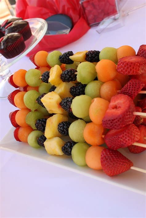 A Bunch Of Fruit Skewers Sitting On Top Of A White Plate