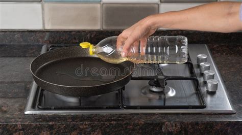 A Woman Hand Pours Vegetable Oil Into A Frying Pan On The Stove Stock Image Image Of Frying