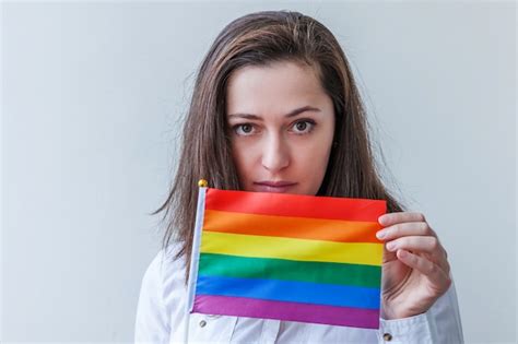 close up of lesbian couple holding lbgt flag in hands free photo