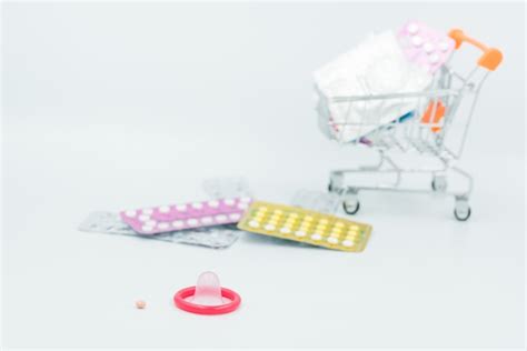 premium photo condom with contraceptive birth control pill safe sex