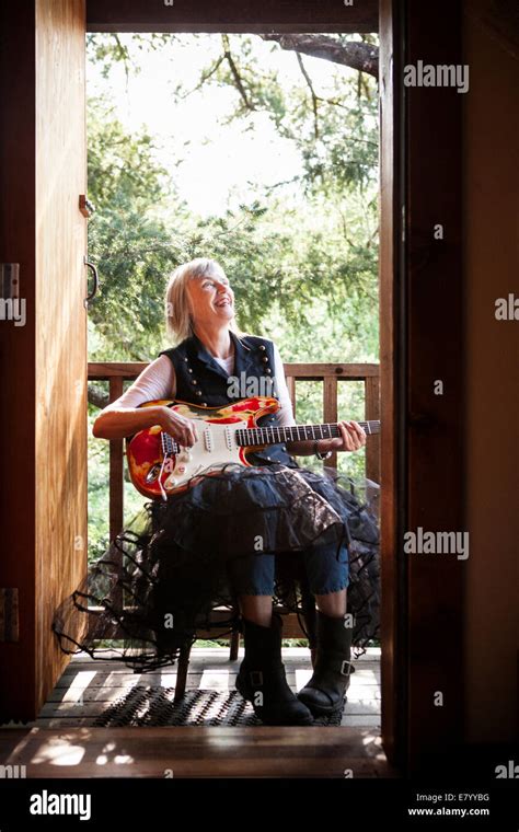 Senior Woman Playing Electric Guitar At Porch Stock Photo Alamy