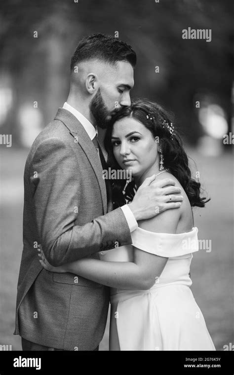 A Beautiful Newly Married Couple Posing In A Park For The Wedding