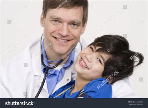 Male Doctor In Early Forties Holding Five Year Old Disabled Patient