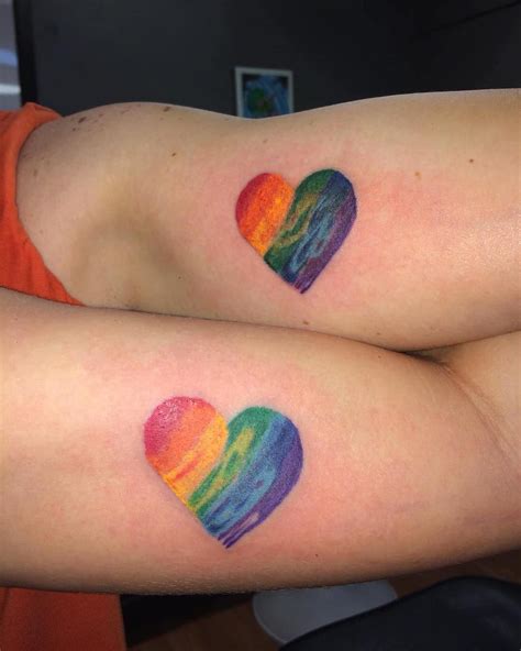 Two People With Rainbow Heart Tattoos On Their Arms