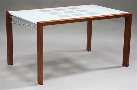 Dwell nox extending dining table in walnut and brushed steel. A modern 'Ligne Roset' dining table and eight chairs, the ...