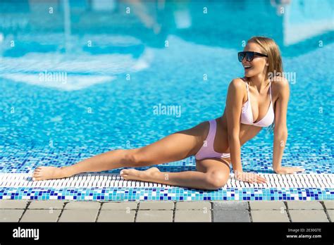 Beautiful Se Woman Lies On The Edge Of The Swimming Pool Sunbathing